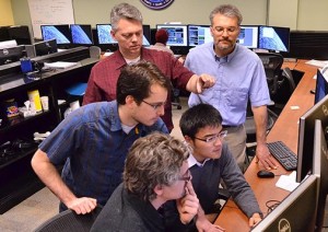Undergraduate students, foreground left to right, Lucas Migliorini, Matt Muszynski, and Hui Kang Ma work in the MMS control room at LASP under the direction of MMS Flight Director Jason Beech, background left, and MMS Science Operations Center Manager Chris Pankratz. (Courtesy Casey A. Cass/University of Colorado)