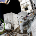 A spacewalking astronaut next to the TSIS instrument mounted on the International Space Station.