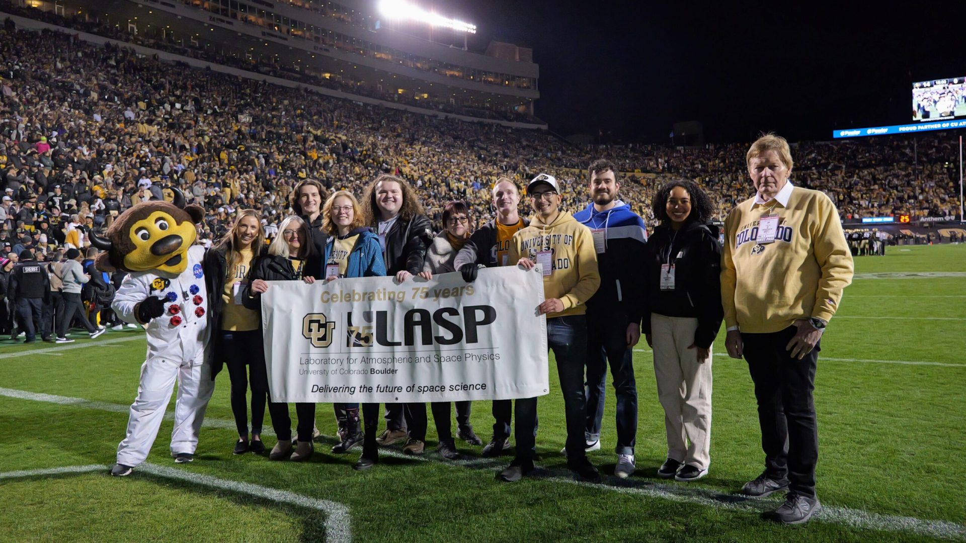 At the Oct. 13 space-themed football game, LASP was honored with an on-field recognition featured 10 CU Boulder graduate and undergraduate students who work at LASP, as well as LASP Director Dan Baker, and LASP Deputy Director Pam Millar. As the group carried LASP’s banner onto the field, the announcer noted that LASP, which was founded in 1948, a decade before NASA, is CU Boulder’s largest research institute and has sent instruments to study every planet in our solar system and beyond. Credit: CU Boulder